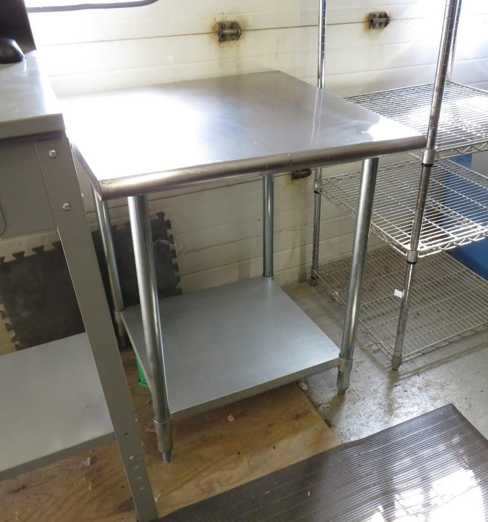 Stainless steel work table with a lower shelf, indoors.