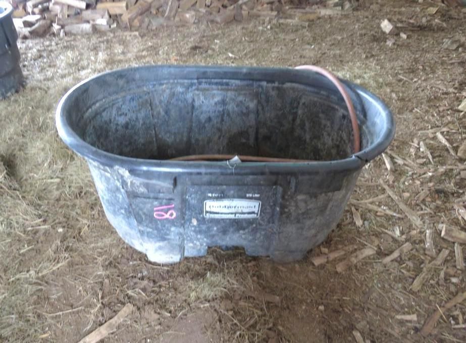 Black oval livestock water trough.