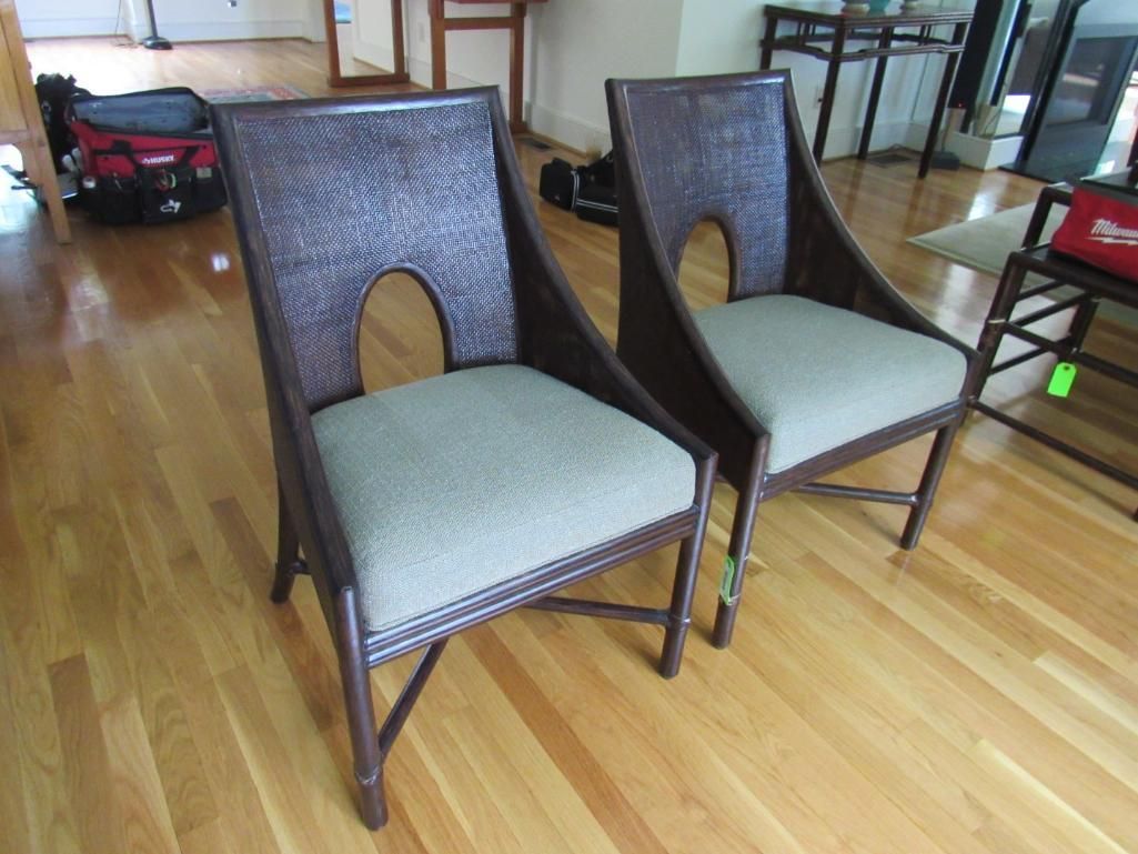 Two brown wicker chairs with oval cutouts on light wood floor.