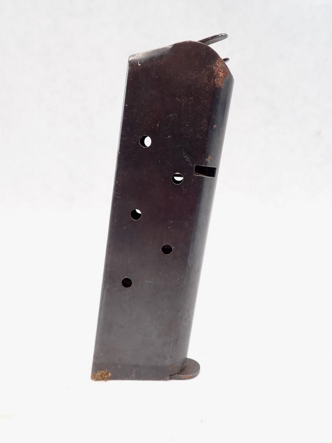Dark metal handgun magazine with several round viewing holes.