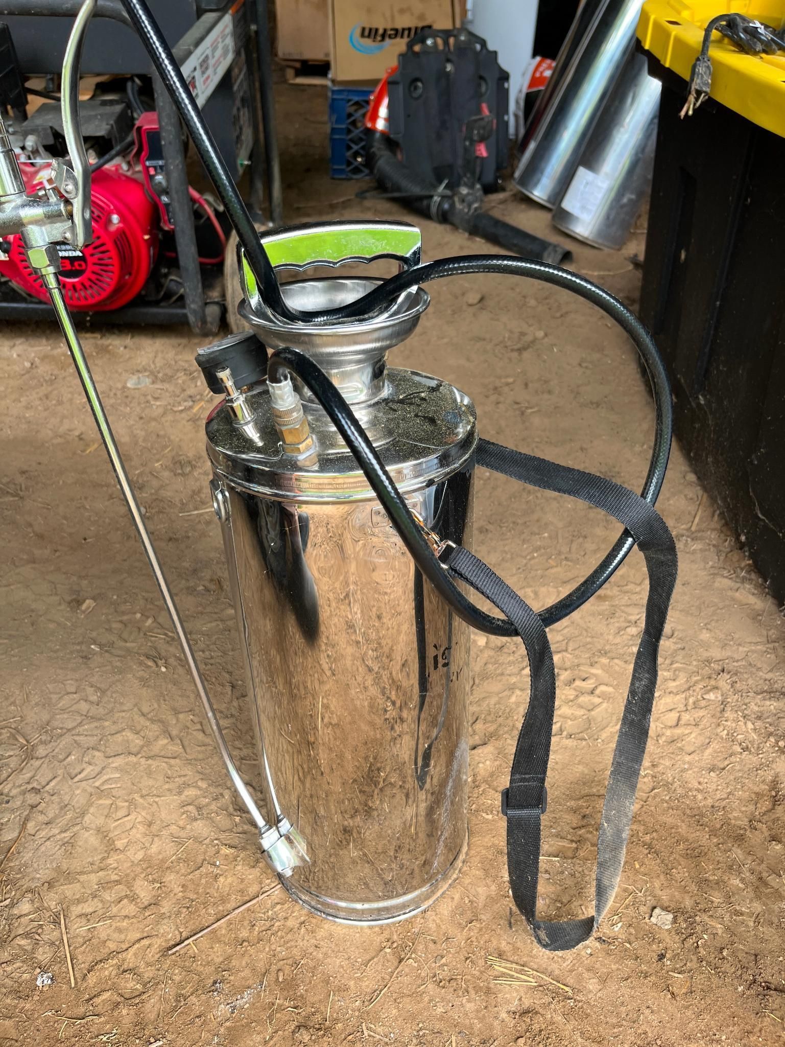 Stainless steel tank sprayer with black straps and wand.