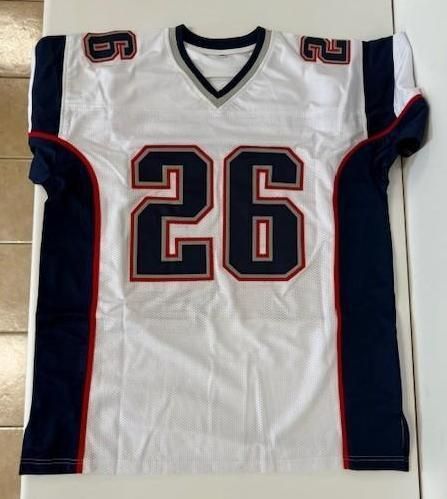 White New England Patriots jersey with navy blue and red accents, number 26 on front and shoulders.