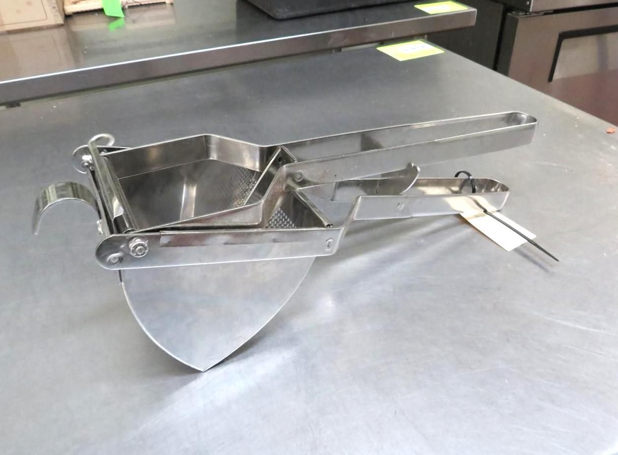 Stainless steel ravioli maker on a metal surface.