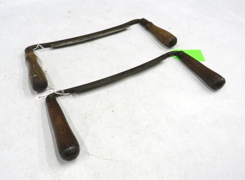 Two drawknives with dark wooden handles and curved blades.