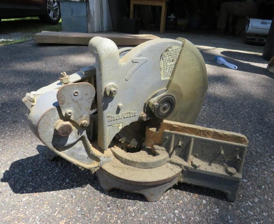 Gray circular saw outdoors on pavement.