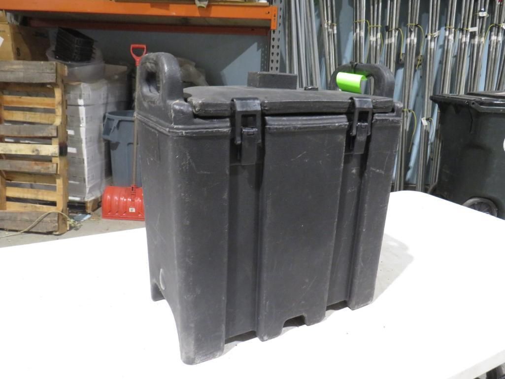 Black rectangular container with latches, handle, and lid on a white surface.