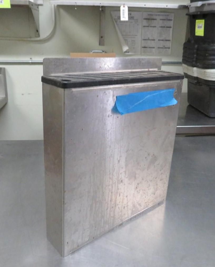 Stainless steel rectangular waste receptacle with blue tape, likely in a commercial kitchen.