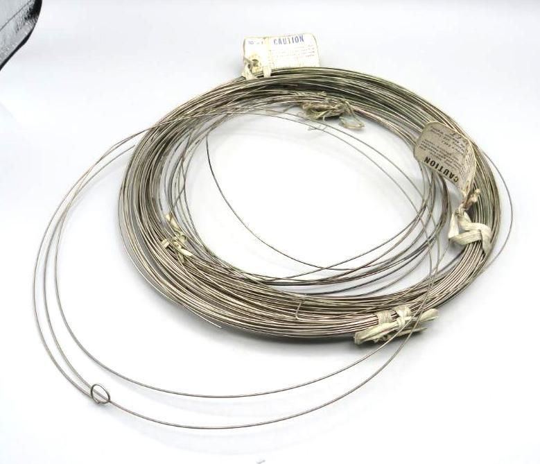 Coiled bundle of thin, silver-colored wire with attached tags.