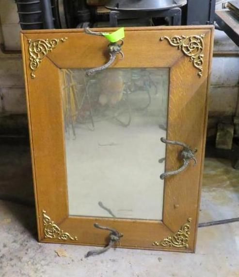 Wooden-framed mirror with ornate corner details, brown rope handles, and a yellow tag.