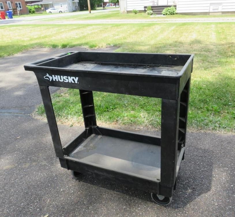 Black Husky utility cart on an asphalt driveway.