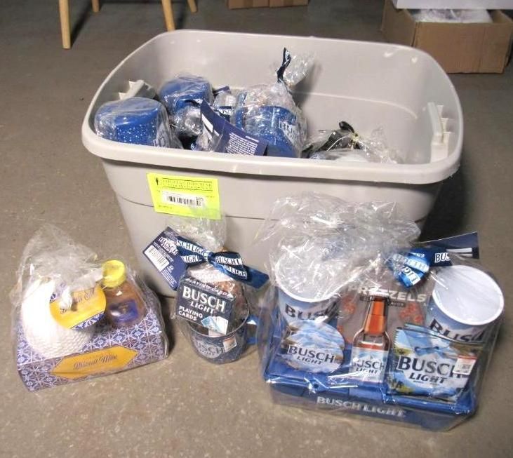 Gift baskets and a bin filled with beer products and snacks, wrapped in cellophane.