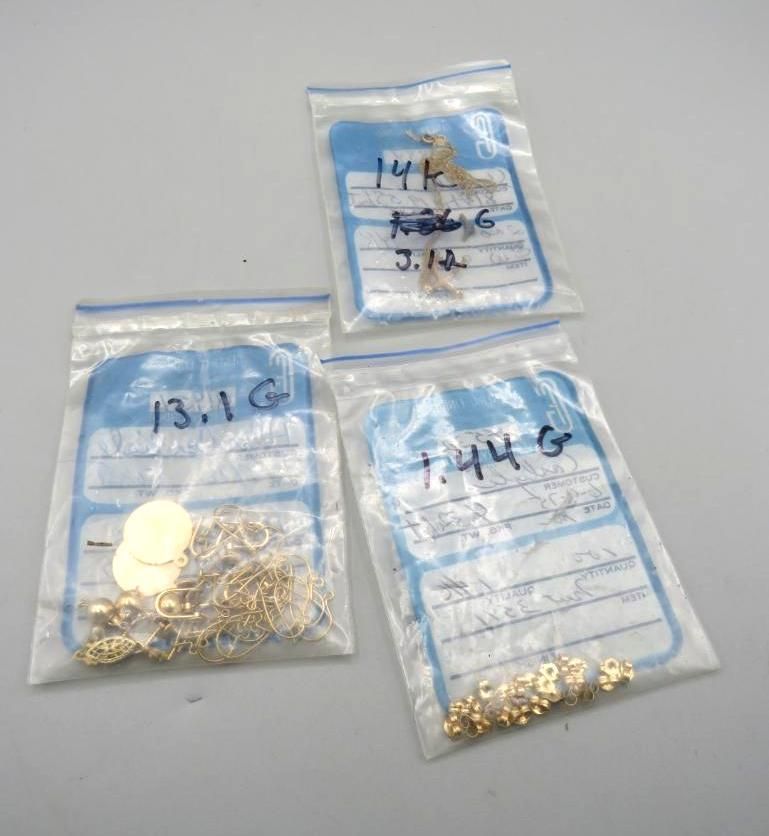 Three plastic bags of gold jewelry, with handwritten labels showing weights and markings.