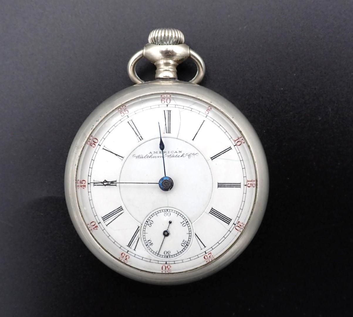 Silver pocket watch with white face, Roman numerals, and subdial.