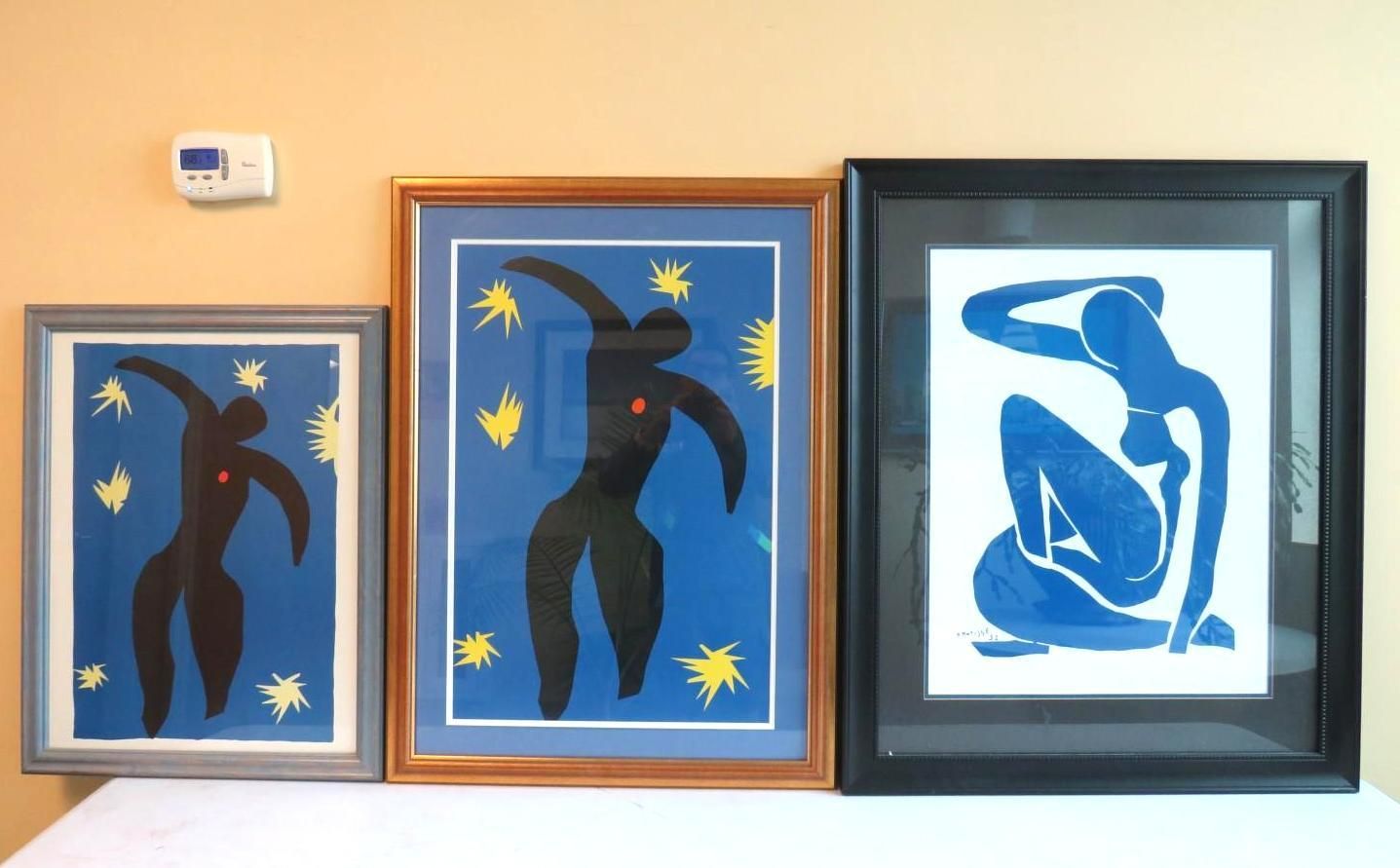 Three framed Matisse-style art prints: two dancers and one seated nude in blue and black, displayed against a peach wall.