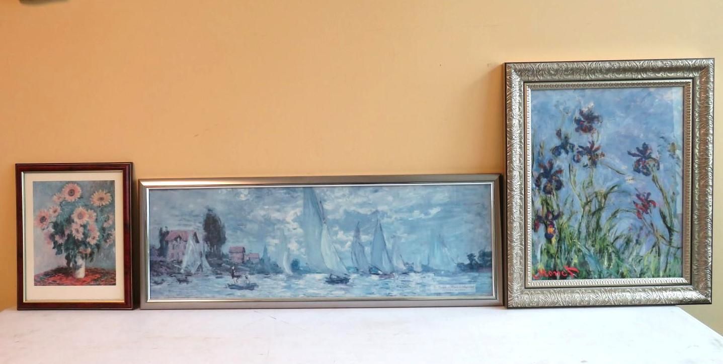 Three framed paintings: a vase of flowers, a seascape, and irises in a field, displayed on a white surface.