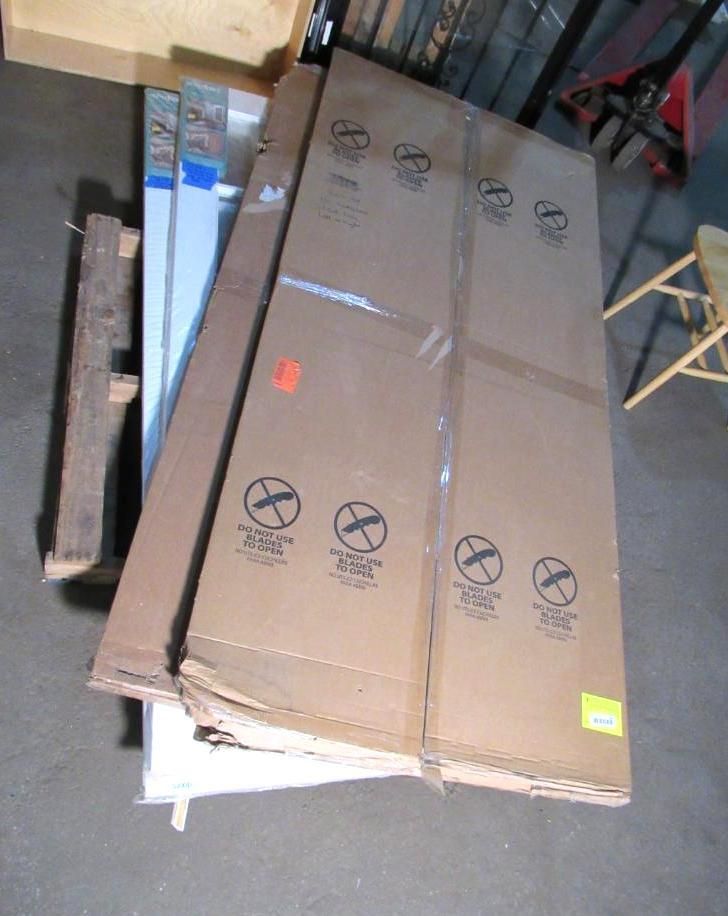 Cardboard boxes and other materials on a pallet in a warehouse setting.