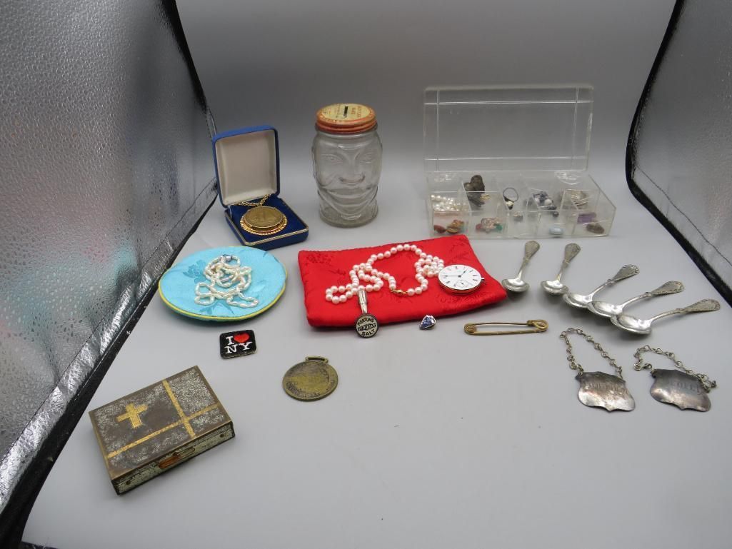 Collection of vintage jewelry and small items displayed on a gray surface.