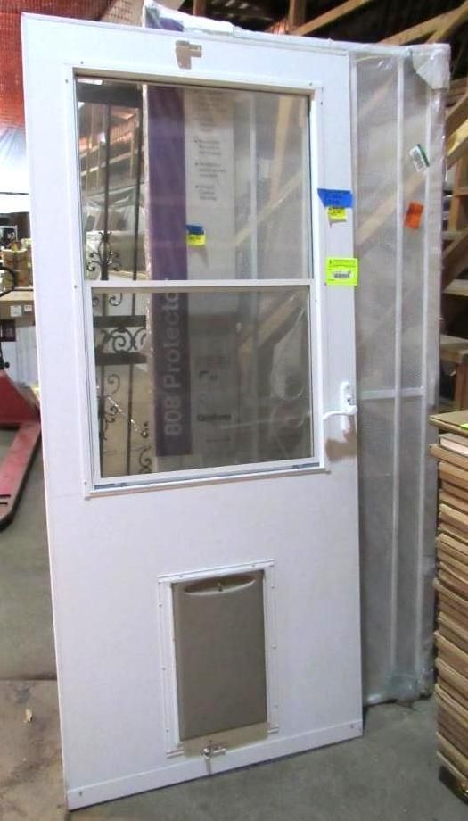 White door with window, pet door, and screen door leaning against wood shelving.