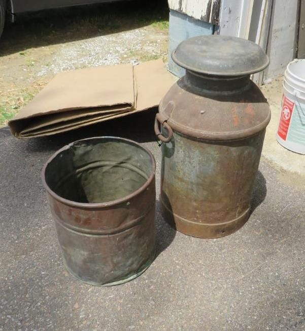 Milk can and bucket on a gray surface.