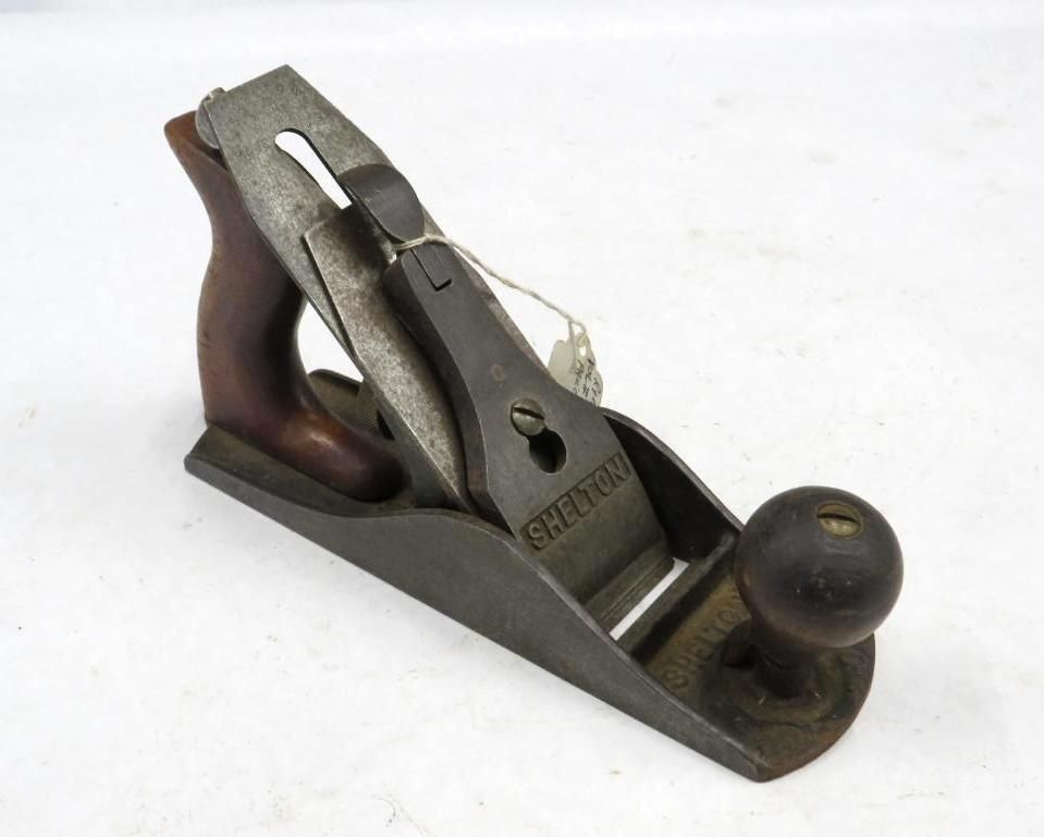 A vintage hand plane with wooden handle and knob, dark metal body.