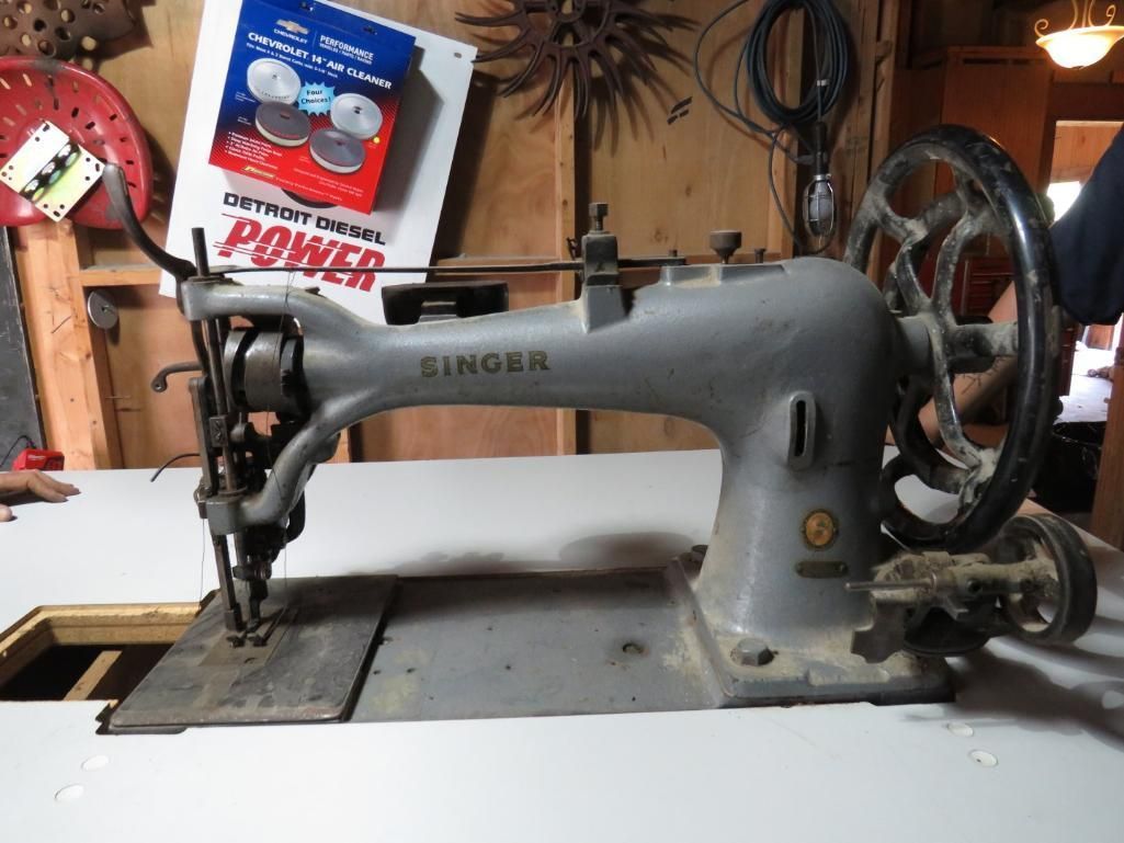 Gray Singer industrial sewing machine on a white surface.