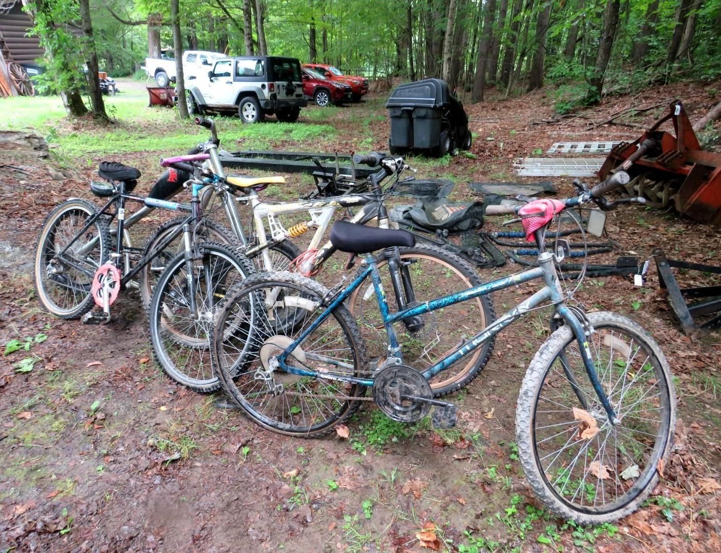 Mountain bikes are parked on dirt road.