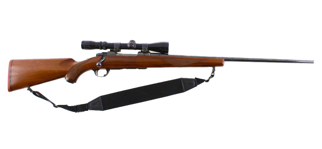 A rifle with a scope and a sling against a white background.