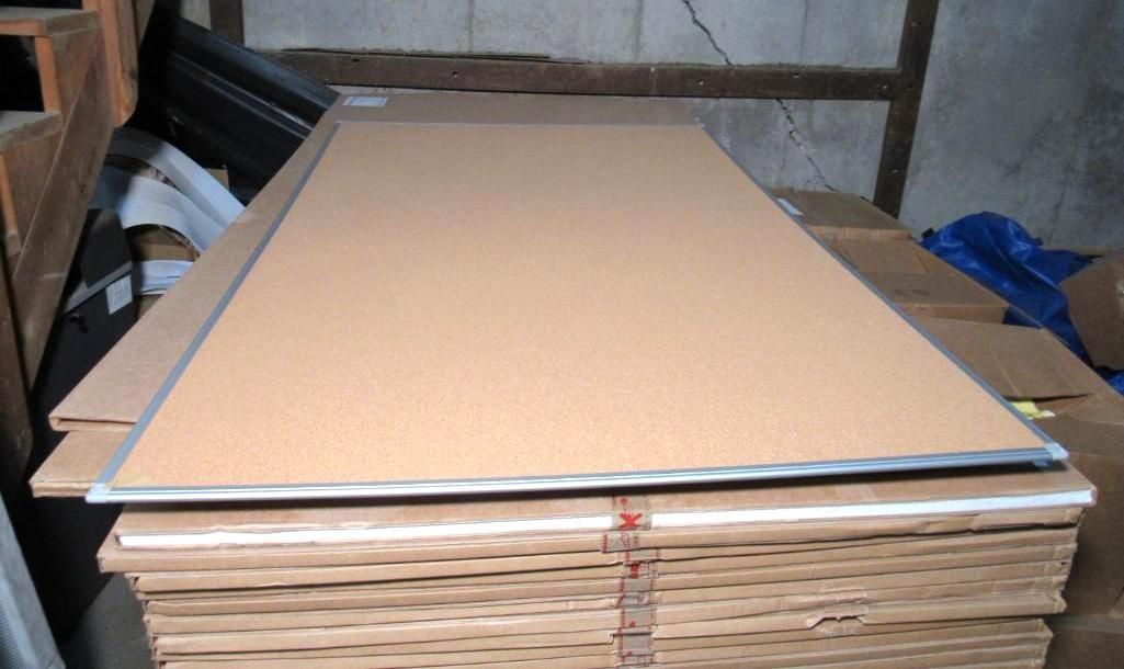 Stack of large cardboard sheets. Top sheet is brown with a silver frame.