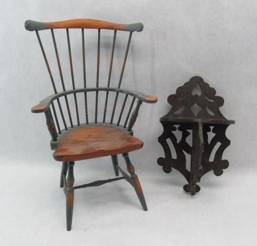 Wooden chair with grey accents next to a dark, decorative wall shelf.