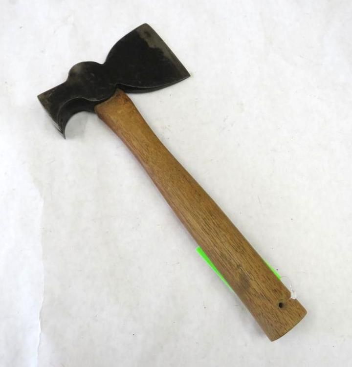 A small axe with a wooden handle, lying on a white surface. The axe head is dark and curved.