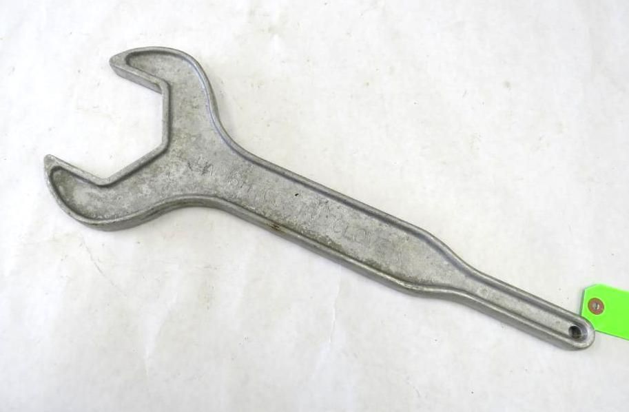 Silver cast metal spanner wrench on a white surface.