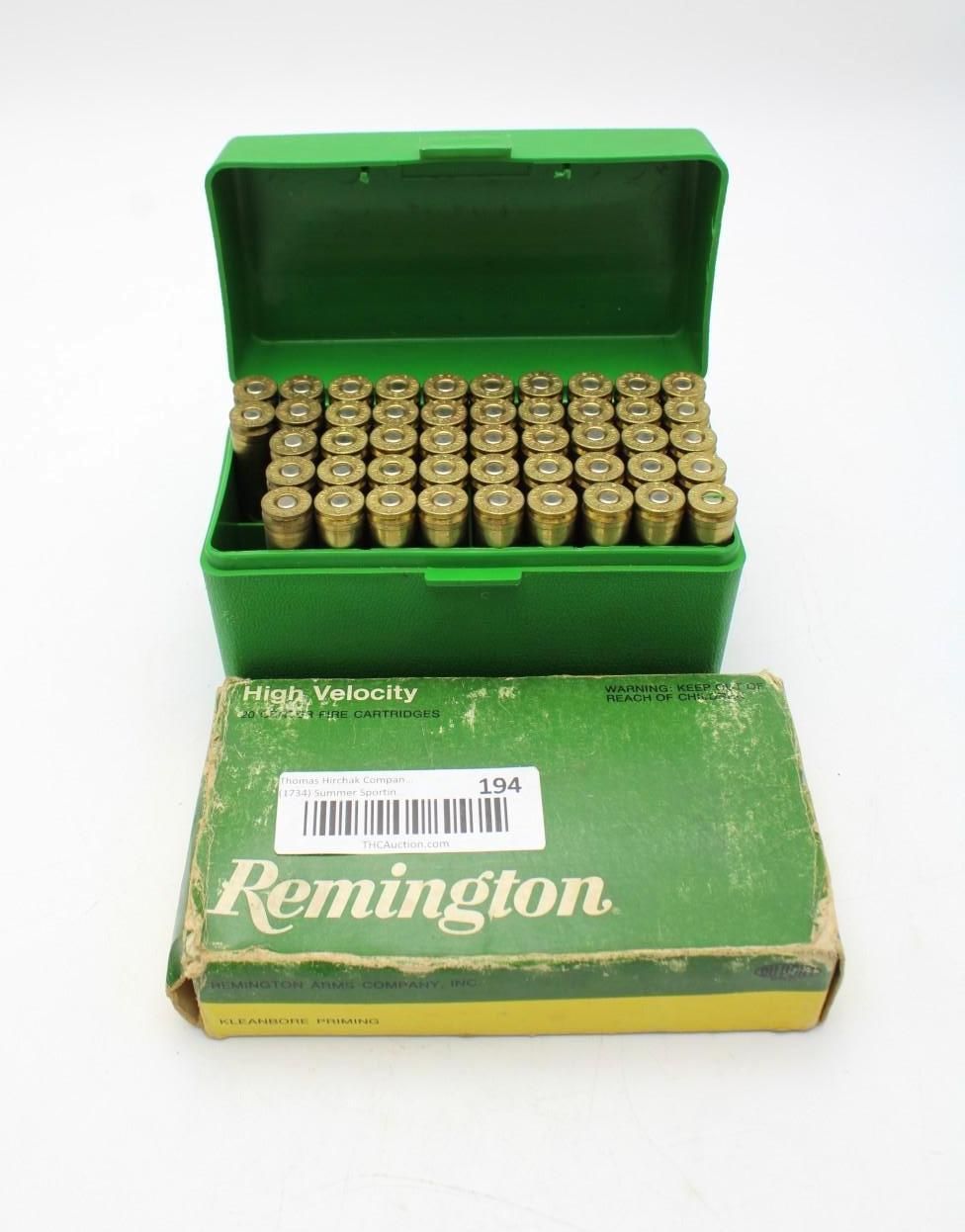 Green Remington ammo box with rows of cartridges and a matching cardboard box in front
