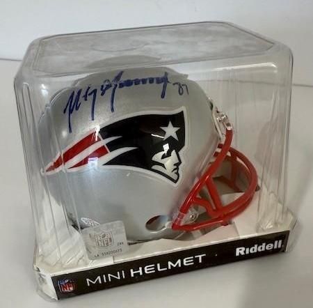 New England Patriots mini helmet, silver, with team logo and autograph, in a clear plastic case.