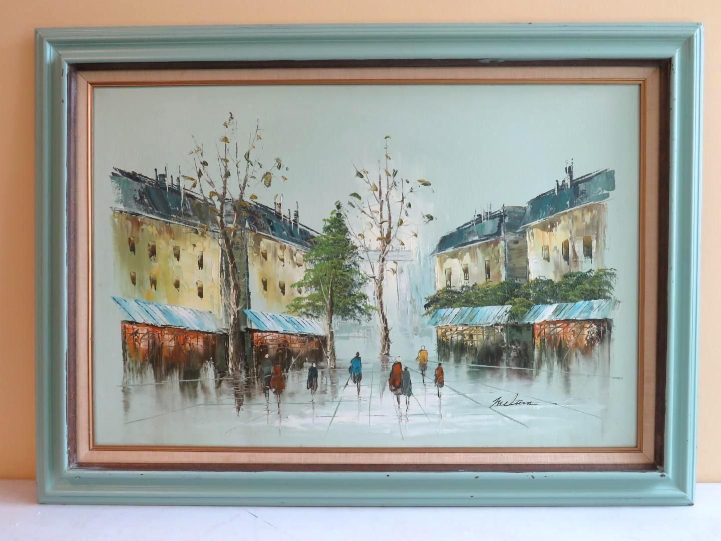 Oil painting of a European street scene with buildings, trees, and people; framed in green.