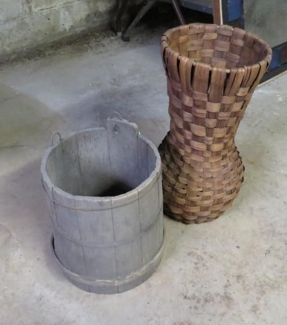 Wooden bucket and woven basket on a concrete floor.