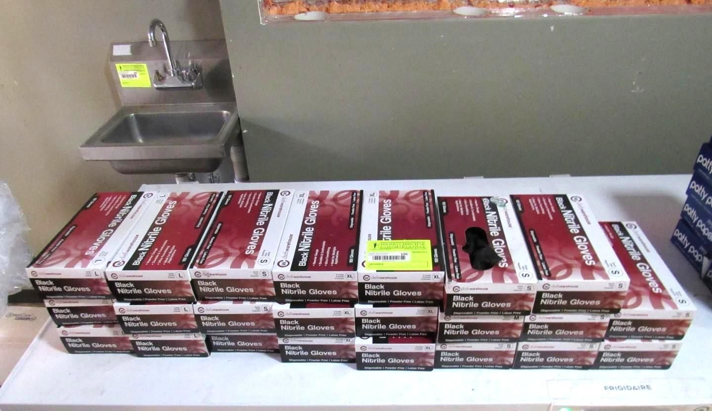 Boxes of medical supplies stacked on a white surface, near a sink.