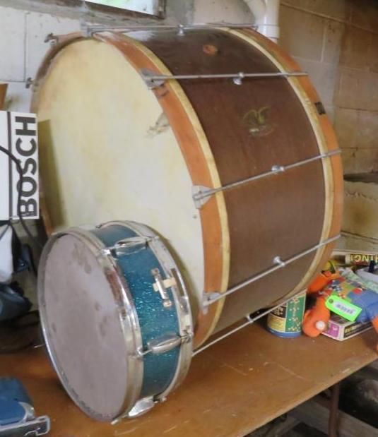 Large brown and tan drum with a smaller blue drum on a table.