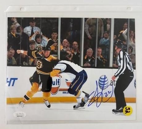 Hockey players in action, one in Bruins uniform and the other in white, with a referee; signed photo.