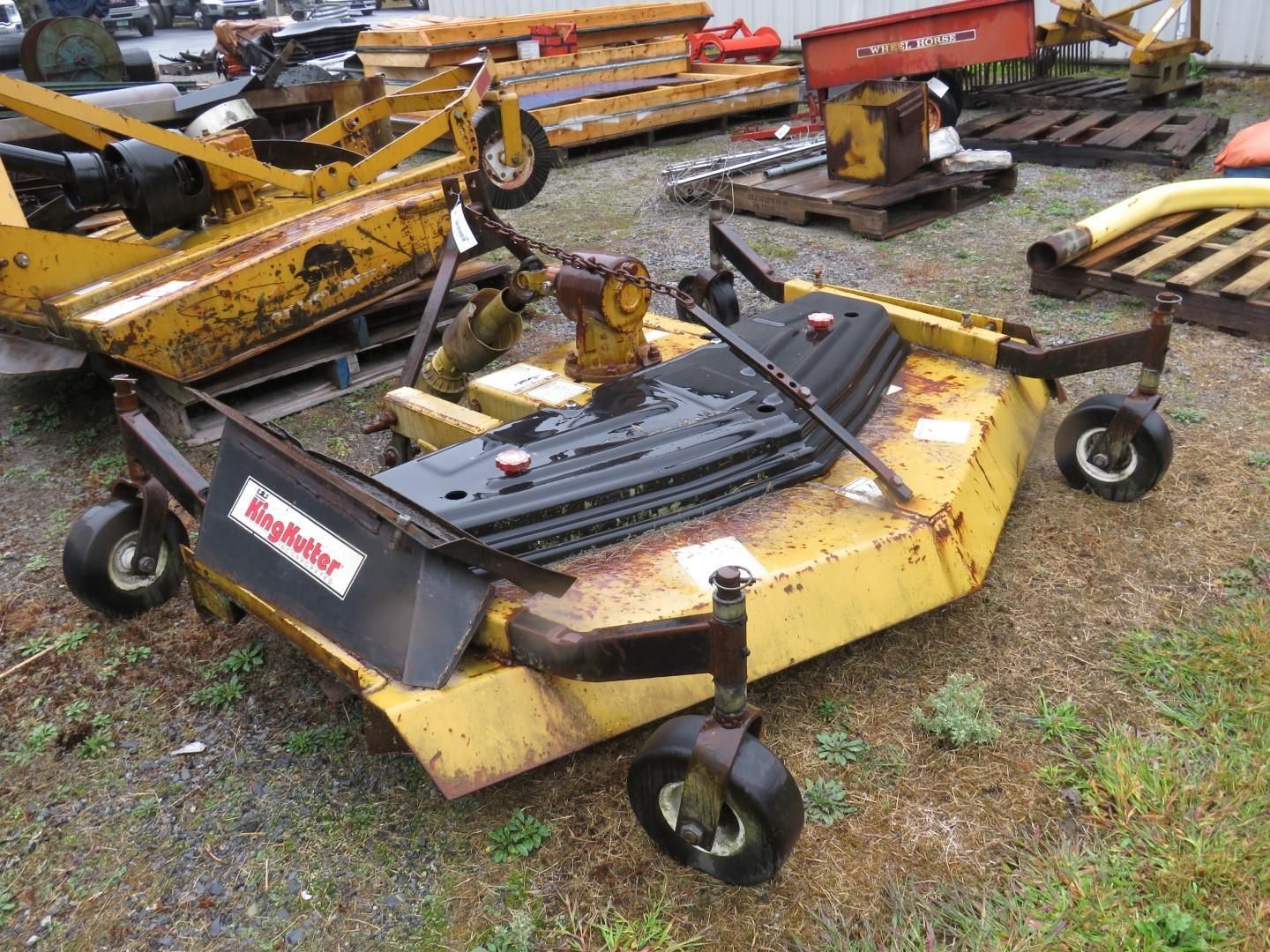 Yellow King Kutter mower on wheels, outdoors.