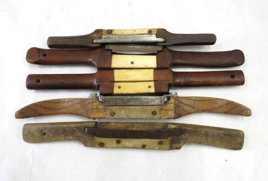 Five draw knives with wooden handles arranged horizontally.