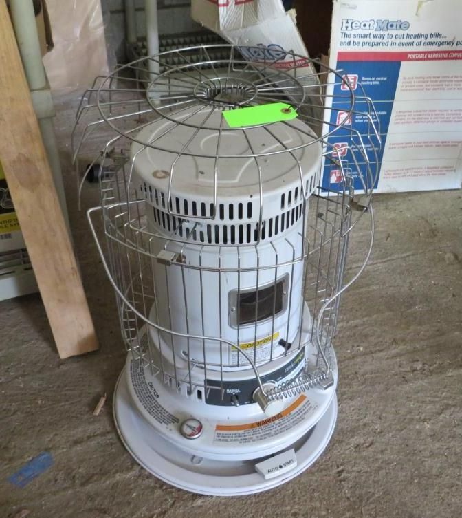 White kerosene heater with a protective cage in an indoor setting.
