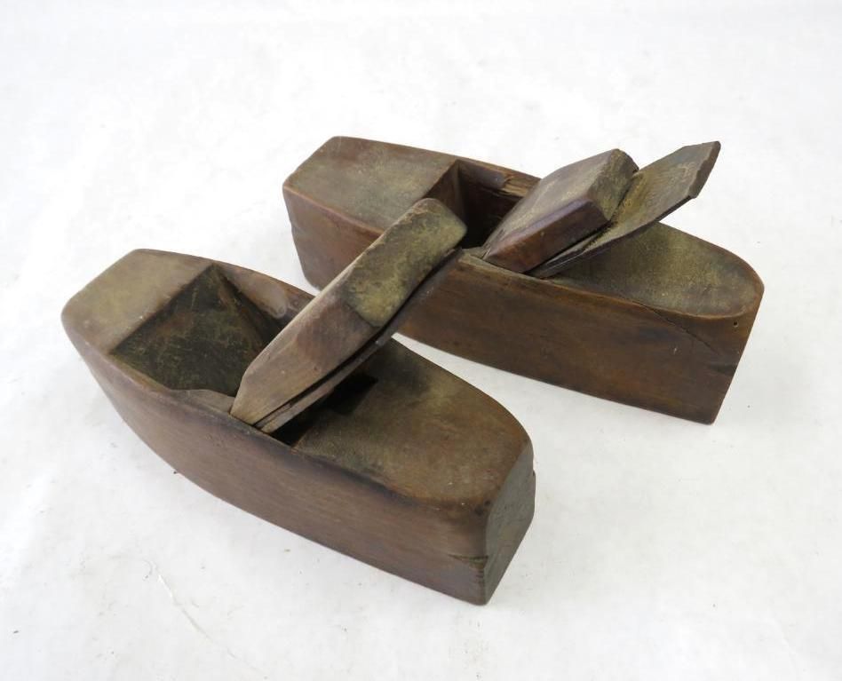 Two wooden block planes, likely antique, on a white surface.