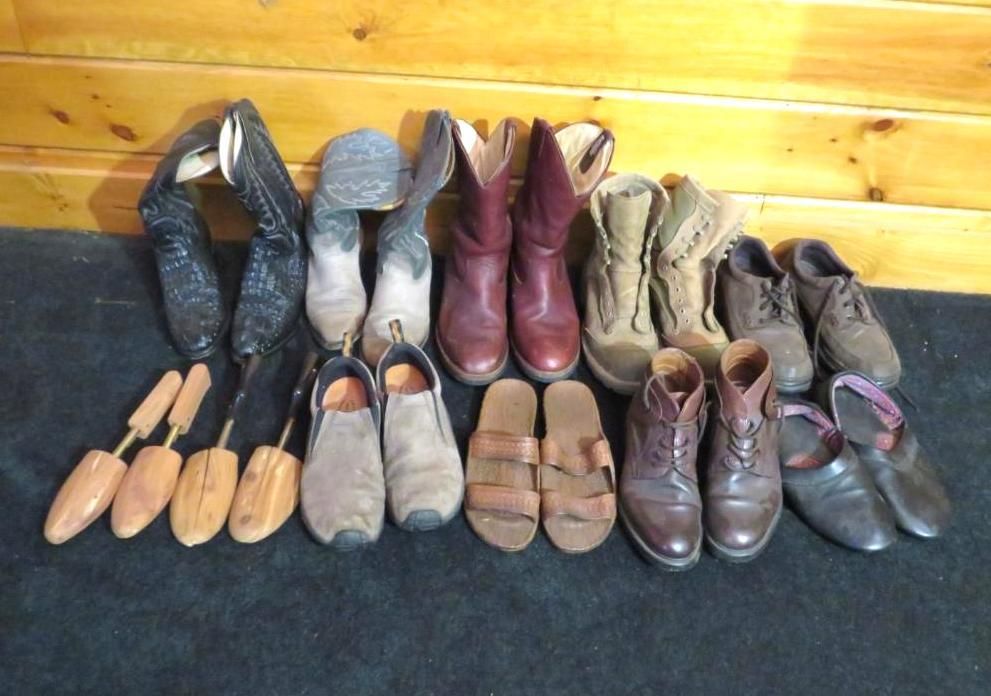 Various pairs of shoes and boots on a dark surface, arranged in two rows.