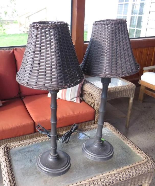 Two dark brown wicker lamps on a glass-topped table.