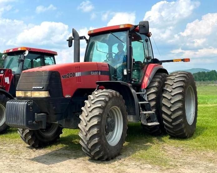 Red Case IH tractor in a field with large tires and a cab.