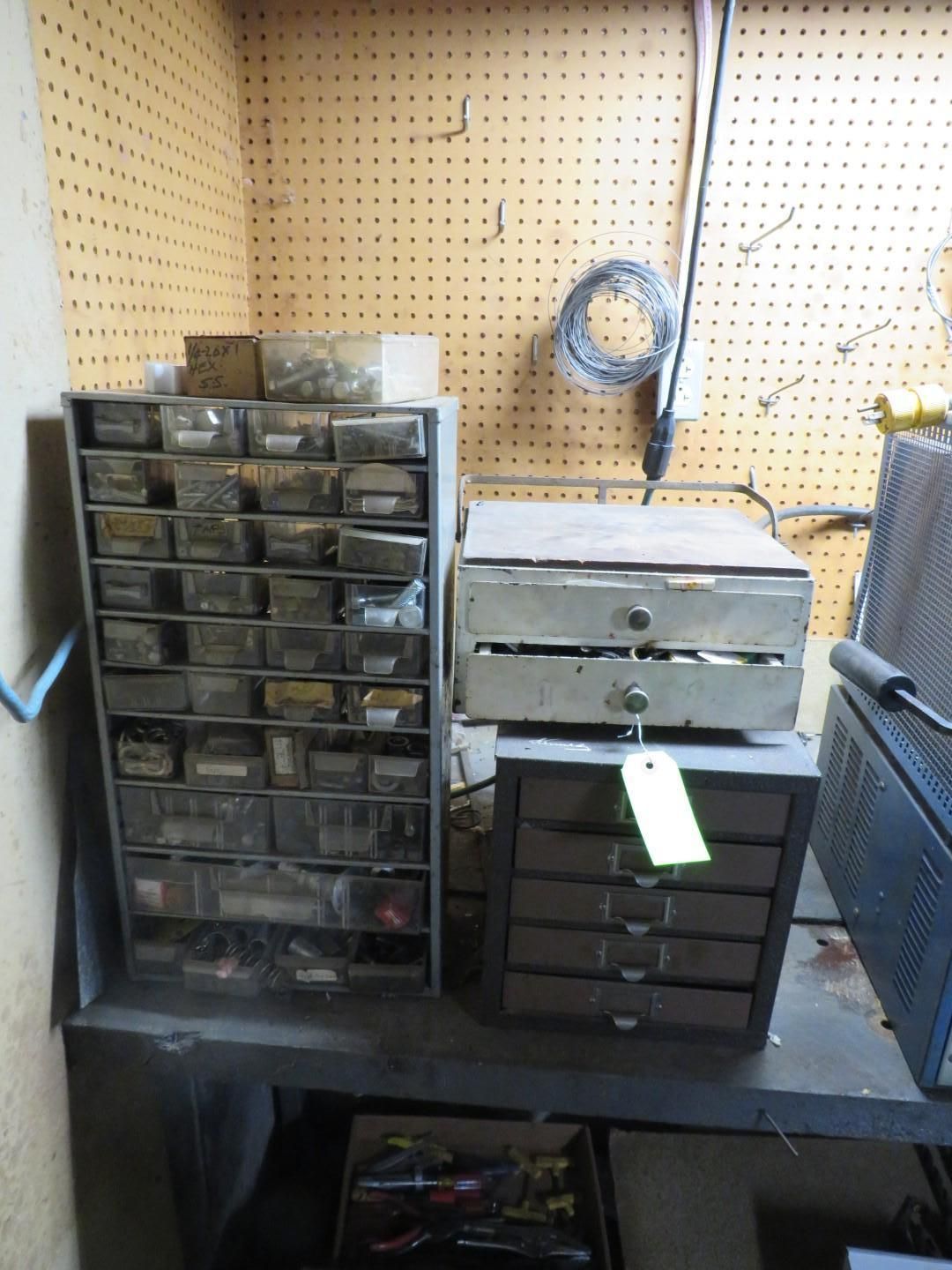 Metal parts organizers with drawers on a shelf in a workshop.
