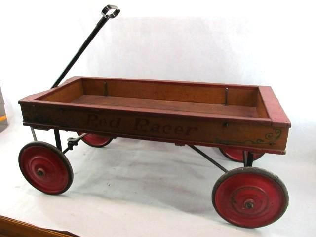Red toy wagon with black handle and wheels.