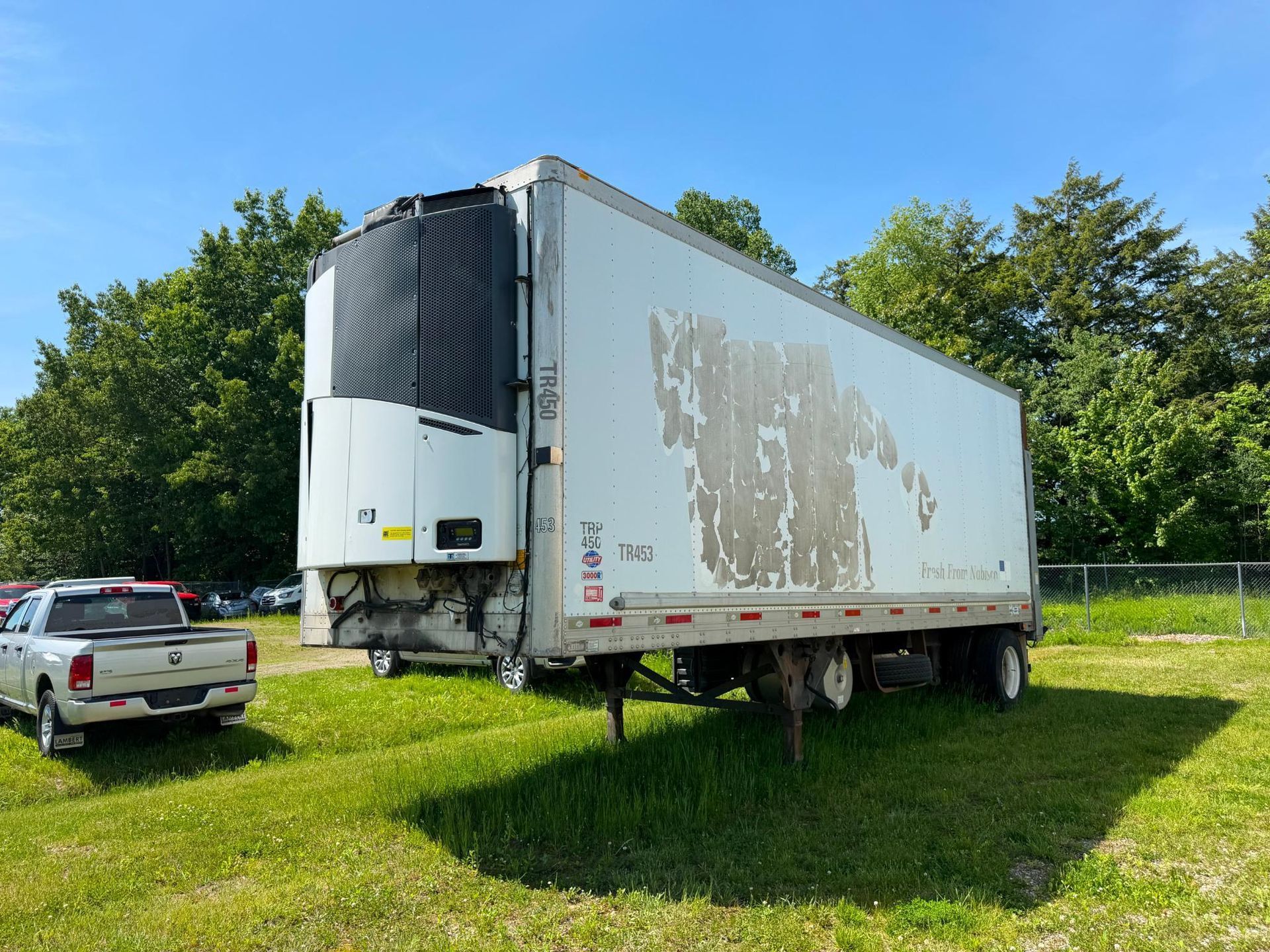 White box trailer parked on grass
