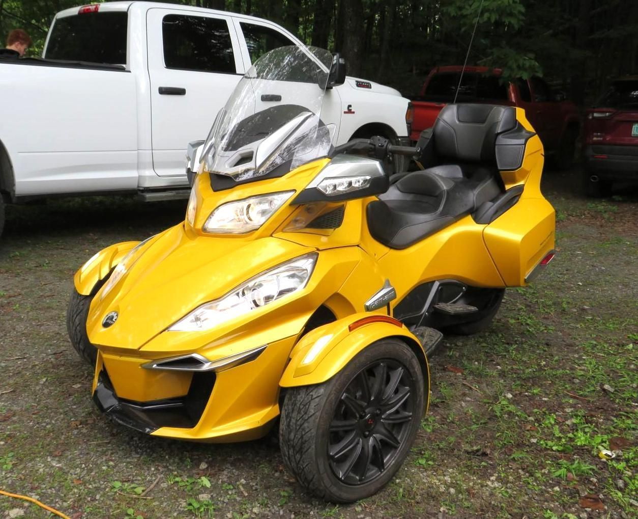 Yellow Can-Am Spyder trike parked outdoors.