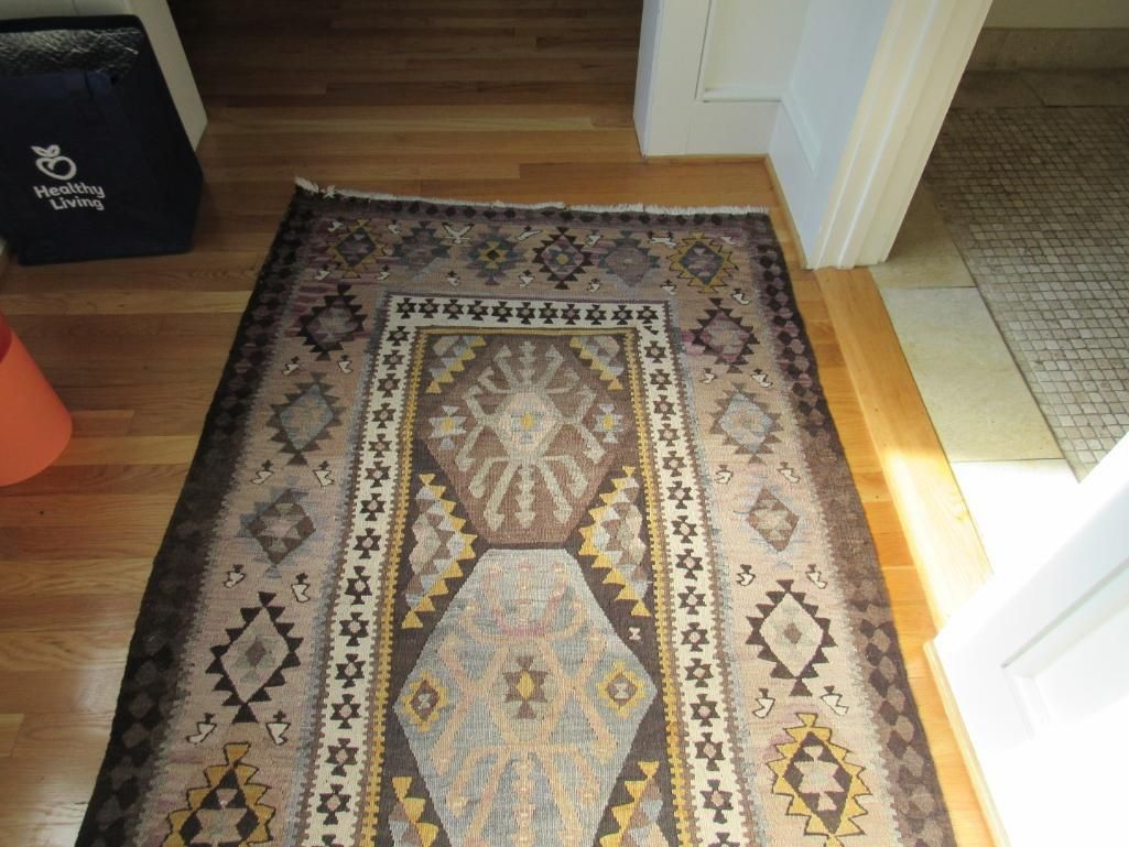 Brown rug on hardwood floor.